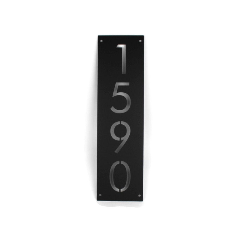 May include: Black metal house number plaque with the numbers 1590 cut out in a vertical line.