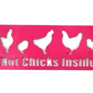 May include: A pink metal sign with the text "Hot Chicks Inside" and five white chicken silhouettes cut out of the metal.