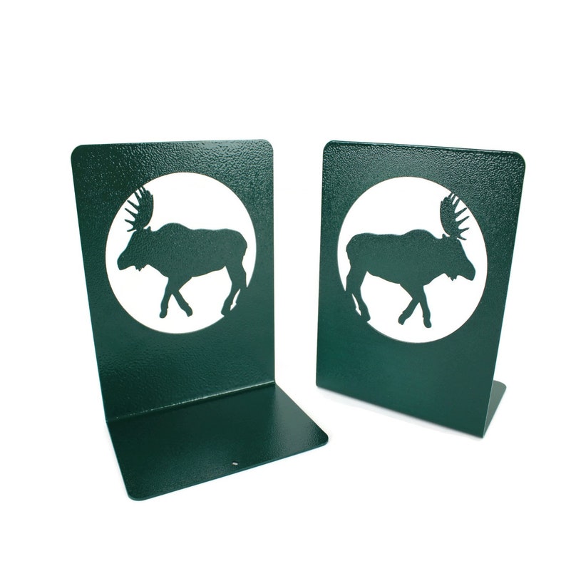 May include: A pair of green metal bookends with a white moose silhouette cutout in a circle on each.