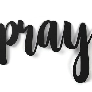 May include: Black metal wall decor with the word "pray" written in a cursive font.