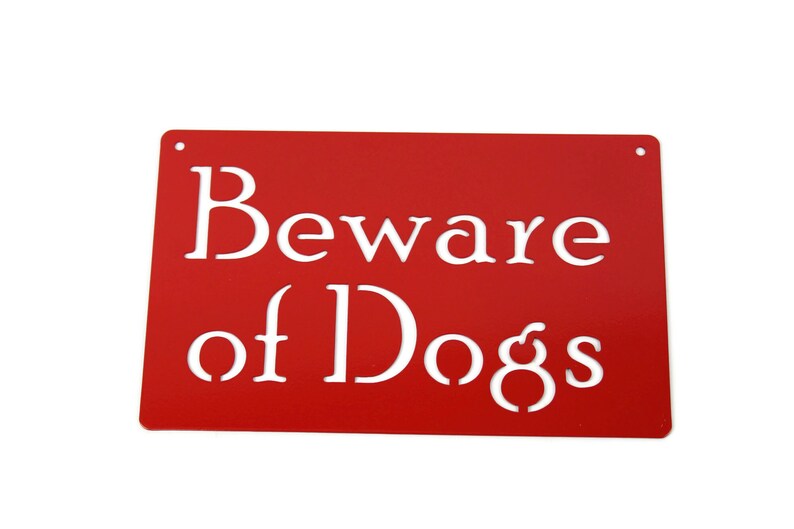 May include: Red metal sign with white text that reads "Beware of Dogs".
