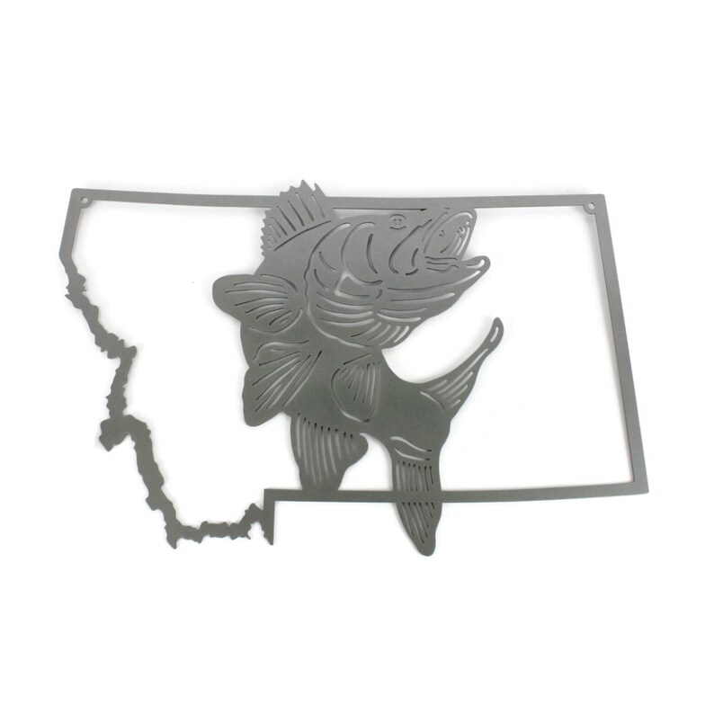 May include: A metal cutout of the state of Montana with a fish jumping out of the outline. The fish is facing right and has a detailed design.