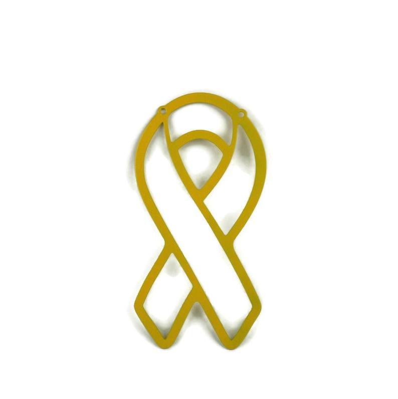May include: A gold-colored awareness ribbon cutout, featuring a looped design with a central vertical band. The ribbon has two small holes at the top for hanging. The background is plain white.