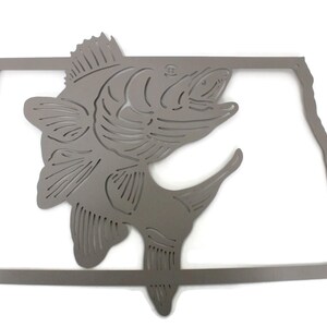 May include: A gray metal wall art piece featuring a leaping fish design within the outline of a state. The fish is detailed with fins and scales, and the state outline is a simple, clean border. The artwork is suitable for indoor or outdoor display.