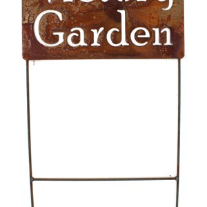 May include: A rectangular, weathered metal garden stake with the words "Victory Garden" cut out in white lettering. The stake has a rusty brown finish and is supported by two thin metal rods.
