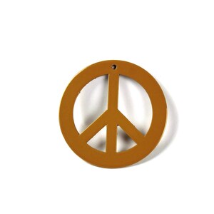 May include: A gold peace sign charm with a hole at the top for hanging.