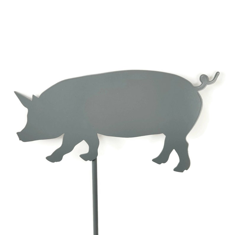 May include: A gray metal pig silhouette garden stake. The pig is facing left and has a curled tail. The stake is attached to the bottom of the pig.
