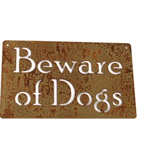 May include: A rusty metal sign with the words "Beware of Dogs" in white lettering.