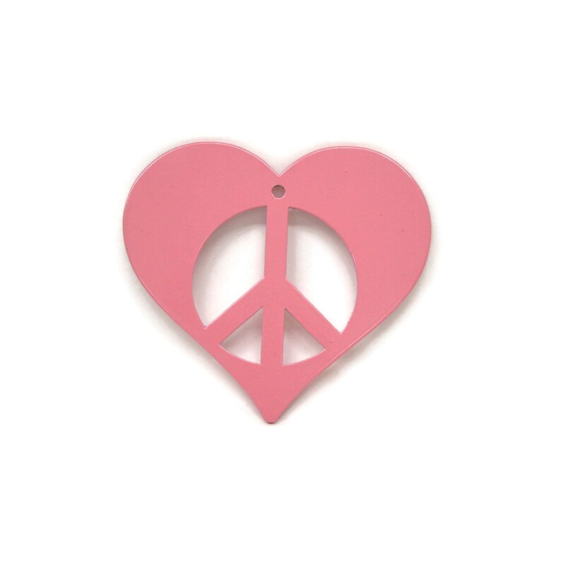 May include: A pink heart-shaped ornament with a peace sign cut out in the center.
