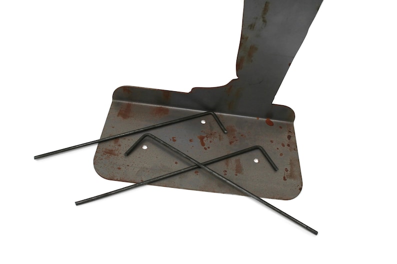 May include: A metal plate with rust spots and three black Allen wrenches. The plate has a curved edge and three holes. The wrenches are different sizes and are arranged on the plate.
