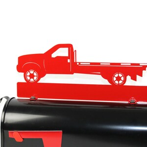 Pode incluir: Tope de caixa de correio de metal vermelho em forma de caminh&atilde;o de plataforma. O caminh&atilde;o est&aacute; em estilo silhueta e tem uma base vermelha.