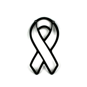 May include: A black ribbon-shaped cutout with a white center, likely a symbol of awareness or support. The ribbon has a smooth, matte finish and two small holes at the top for hanging or attachment. The design is simple and graphic.