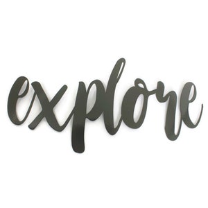 May include: Black metal wall decor with the word "explore" written in a cursive font.