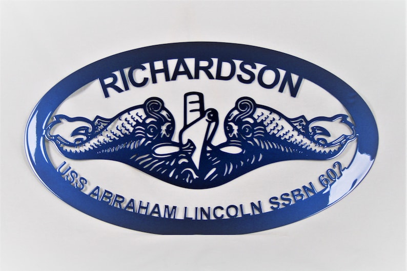 May include: A blue oval metal sign with the text "USS Abraham Lincoln SSBN 602" and "Richardson" in a white font. The sign features a stylized image of a submarine with two dolphins flanking it.