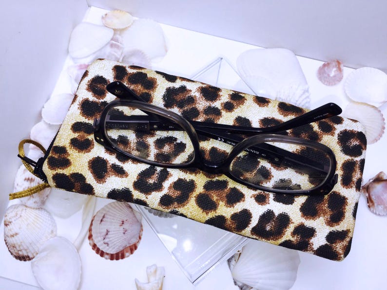 Pode incluir: Um estojo para &oacute;culos de estampa de leopardo com um par de &oacute;culos de arma&ccedil;&atilde;o preta dentro.