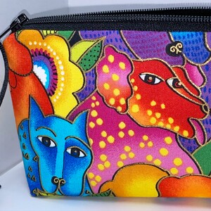 May include: A colorful zippered pouch with a black zipper and a black cord with beads. The pouch features a whimsical design of stylized dogs and flowers in shades of red, orange, yellow, green, blue, and purple.