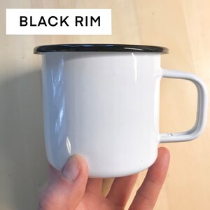 May include: White enamel mug with a black rim and a handle.