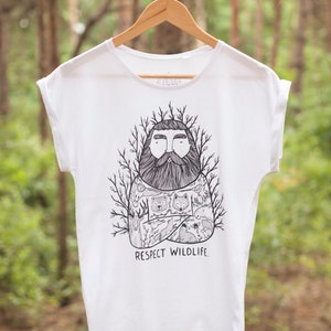 Könnte beinhalten: Weißes T-Shirt mit einer schwarz-weißen Illustration eines bärtigen Mannes mit einer Waldszene und Tieren auf seiner Brust. Der Text "Respect Wildlife" ist unter der Illustration gedruckt.