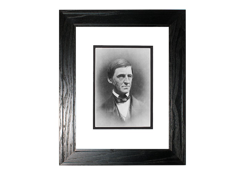 May include: Black and white portrait photograph of a man in a framed setting. The man is wearing a dark suit and a bow tie. The photograph is in a black wood frame with a white mat.