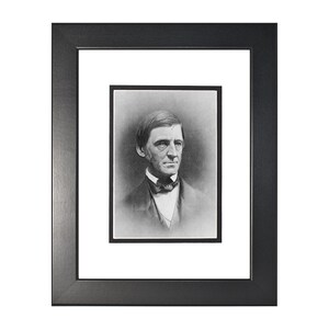 May include: Black and white portrait photograph of a man in a suit and bow tie. The man is looking directly at the camera. The photograph is framed in a black frame with a white mat.