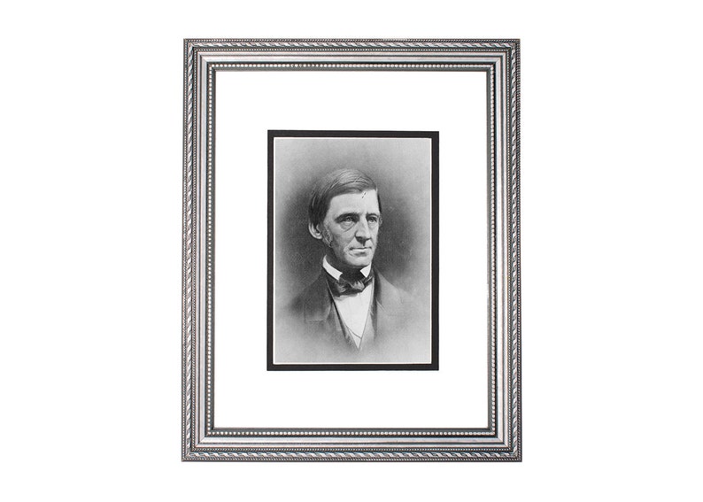 May include: A black and white portrait of a man in a framed photograph. The man is wearing a dark suit with a white shirt and a bow tie. He has a serious expression on his face.