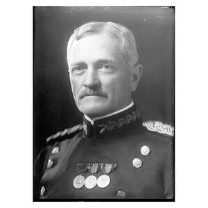 May include: A black and white portrait of a man in military uniform. He is wearing a dark uniform with medals and buttons. He has a mustache and short, gray hair.