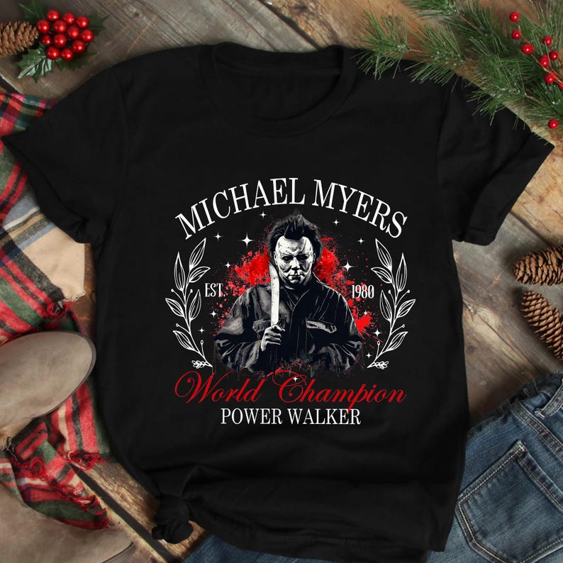 May include: Black t-shirt with a graphic of Michael Myers holding a knife, the text "MICHAEL MYERS" above and "World Champion Power Walker" below. The design includes a red splatter effect and the year 1980.
