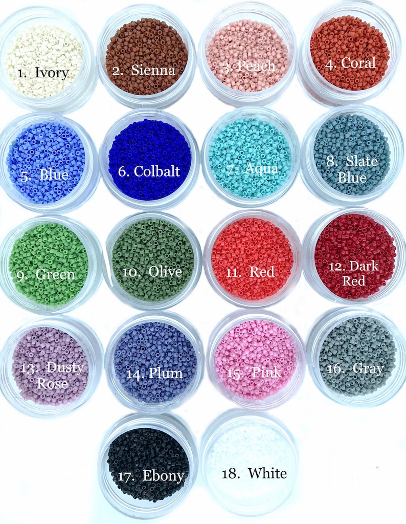 May include: Eighteen clear circular containers filled with small, cylindrical beads in various colors, labeled 1 through 18. Colors include ivory, sienna, peach, coral, blue, cobalt, aqua, slate blue, green, olive, red, dark red, dusty rose, plum, pink, gray, ebony, and white.