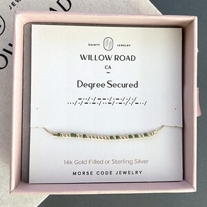 May include: A delicate gold-filled or sterling silver Morse code bracelet with green beads, presented in a pink box. The card inside reads "Degree Secured" and "Willow Road CA". The jewelry is described as Morse Code Jewelry.