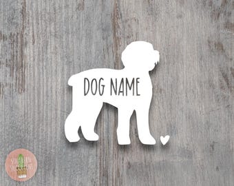 May include: A white vinyl decal in the shape of a dog silhouette featuring the text DOG NAME printed in a dark gray sans-serif font across the body and a small white heart icon positioned near the front paws of the dog figure.