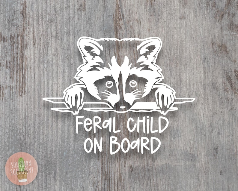 May include: A white vinyl decal featuring a stylized raccoon peering over a horizontal line with its paws visible. Below the raccoon, the text reads FERAL CHILD ON BOARD in a casual, hand-lettered font. The design is presented as a single graphic element.
