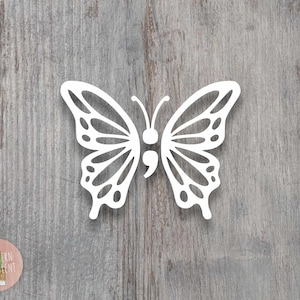 May include: A white butterfly decal featuring a semicolon symbol integrated into the center of its body. The butterfly has symmetrical, intricate wing patterns with cut-out sections, two thin antennae, and a rounded head, presented as a flat graphic.