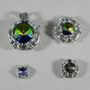 May include: Four silver wire wrapped pendants with iridescent glass stones. The largest pendant has a green, blue, and yellow stone. The other three pendants have smaller stones in shades of blue, green, and purple.