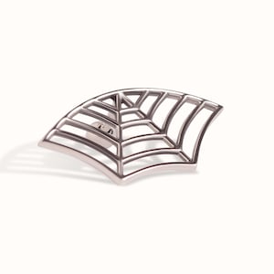 May include: A silver-toned metal pin shaped like a segment of a spider web. The design features a series of curved, radiating lines intersected by concentric arcs, creating a geometric grid pattern with a polished, metallic finish and a pin back.