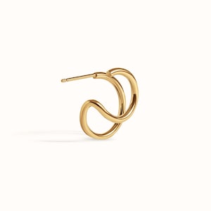 Puede incluir: Pendientes de aro dobles de color dorado con un dise&ntilde;o retorcido. Los pendientes est&aacute;n hechos de un metal liso y brillante.