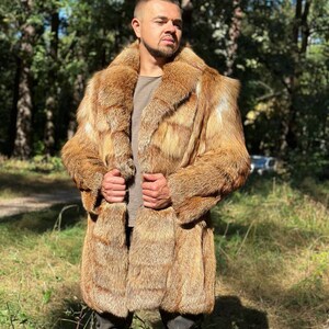 May include: A long, brown fur coat with a large collar. The coat is made of fox fur and has a button closure.