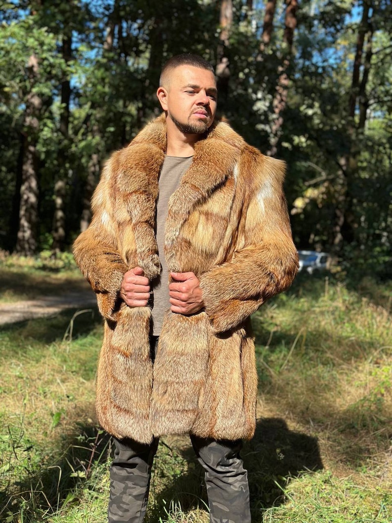 May include: A long, brown fur coat with a large collar. The coat is made of fox fur and has a button closure.