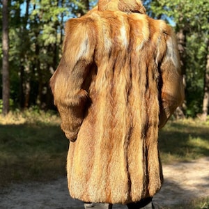 May include: A long, brown fur coat with a high collar. The coat is made of fox fur and has a soft, luxurious feel.