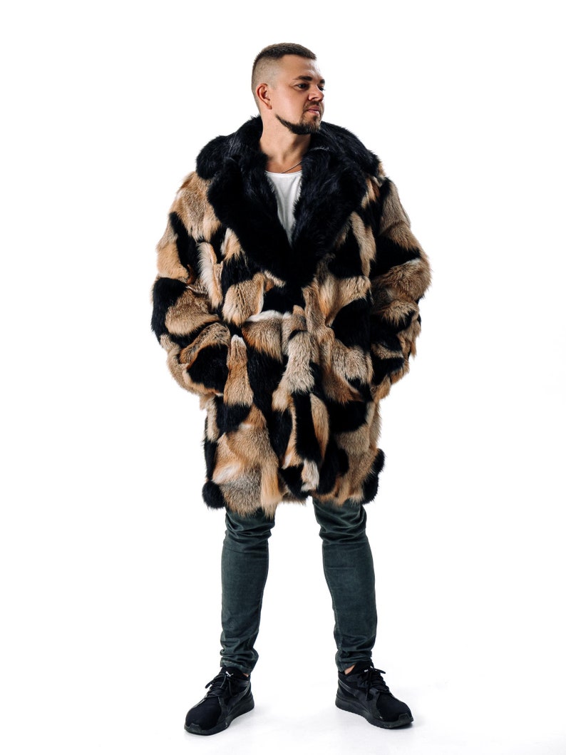 May include: A long, brown and black fur coat with a large collar. The coat is worn by a person standing on a white background.