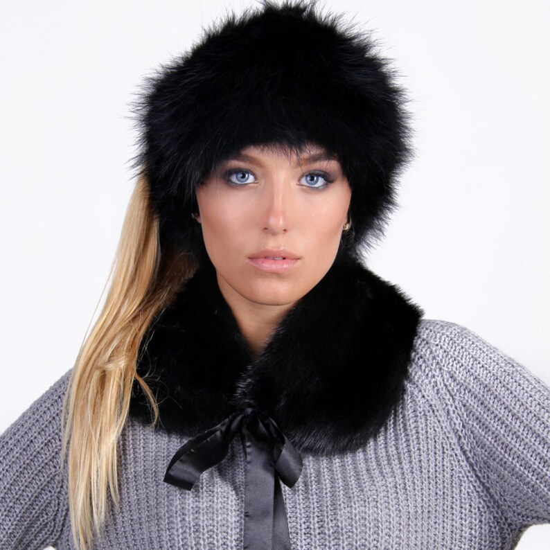 Puede incluir: Un gorro de piel negro y un cuello de piel a juego. El gorro se lleva en la cabeza de una persona con el pelo largo y rubio. El cuello se lleva alrededor del cuello de una persona que lleva un su&eacute;ter gris.