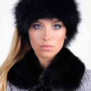Puede incluir: Un gorro de piel negro y un cuello de piel a juego con un lazo de sat&eacute;n negro.