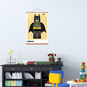 May include: A framed poster with a Lego Batman character illustration. The poster has a yellow background with a black frame and the word "batman" printed at the bottom.