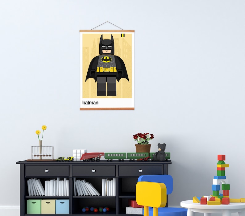 May include: A framed poster with a Lego Batman character illustration. The poster has a yellow background with a black frame and the word "batman" printed at the bottom.