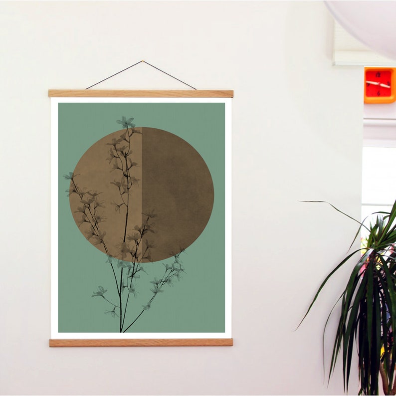 May include: A framed print with a minimalist design featuring a brown circle with a branch of delicate white flowers in front of it. The background is a muted teal green.