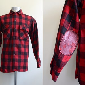 Puede incluir: Camisa de franela a cuadros rojos y negros de manga larga con parches de cuero en los codos.