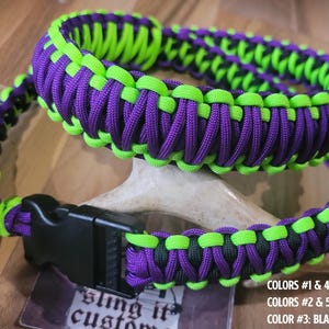 May include: Two paracord bracelets in neon green, purple, and black. The bracelets are made of woven nylon cord and feature a black plastic buckle. The bracelets are resting on a deer antler. The text on the tag reads "sling it custom".
