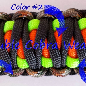 May include: Close-up of a double cobra weave paracord bracelet with four colors: camouflage, black, lime green, and orange. The bracelet is made with a double cobra weave pattern, which creates a strong and durable bracelet.