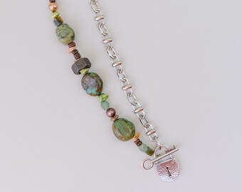 May include: A silver chain bracelet with a lock charm and green, brown, and beige beads.