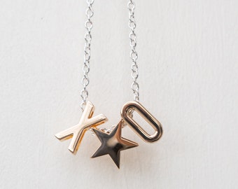 May include: A silver chain necklace with a gold star, X, and O pendant.
