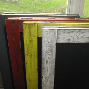 May include: A set of five framed chalkboard signs with different colored frames. The frames are gray, red, yellow, white, and a light wood color. The signs are all the same size and have a black chalkboard surface.